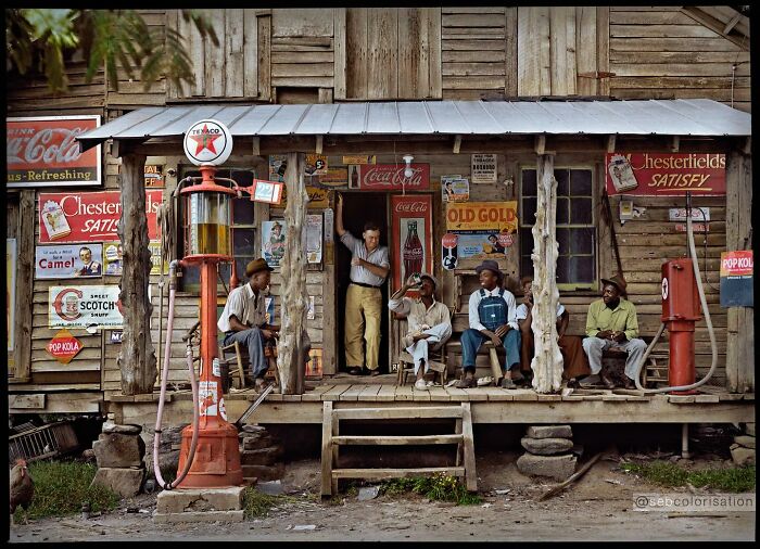 Porch scene of a vintage wooden store with men sitting and standing, colorized historical photo by a viral artist.