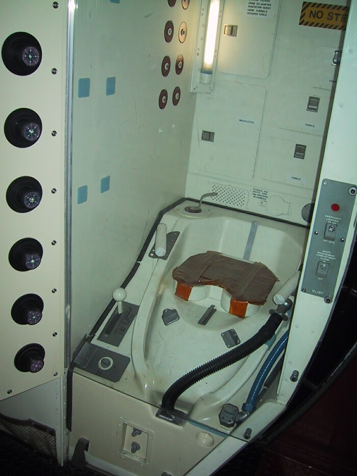 Space toilet inside a spacecraft, showcasing unique astronaut equipment related to intriguing and bizarre astronaut facts.