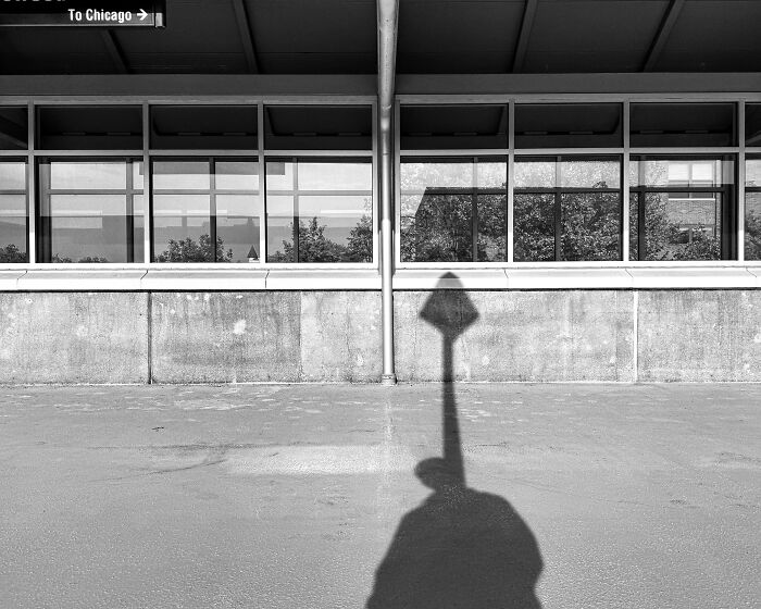 Black and white street photo in Chicago with shadow of a person and urban architecture reflecting the city’s soul.