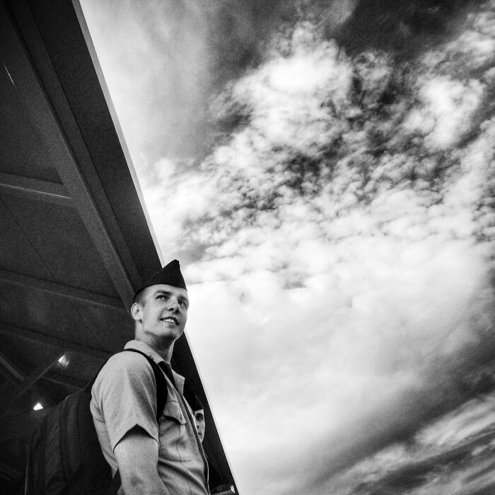 Young man in uniform under a cloudy sky captured in intimate street photos of Chicago by a local teacher