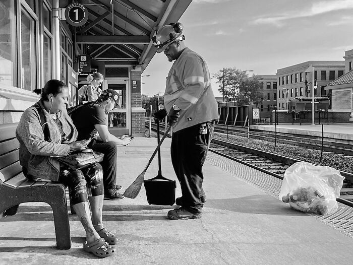 Chicago street scene with a worker sweeping platform as commuters wait, capturing the city’s soul in intimate street photos.