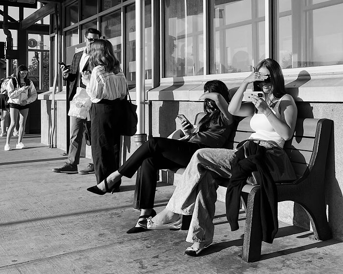 Chicago street photo showing people sitting and standing outside a building, capturing the city’s everyday moments.