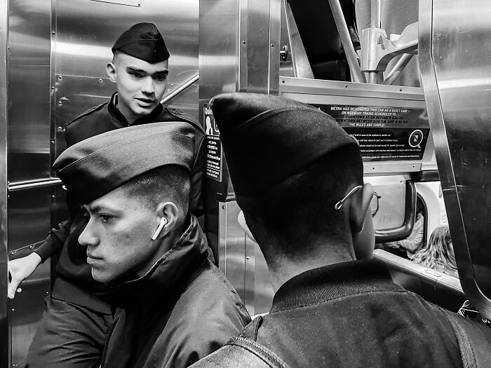 Three young men in military-style hats inside a train, part of intimate street photos capturing Chicago’s soul.