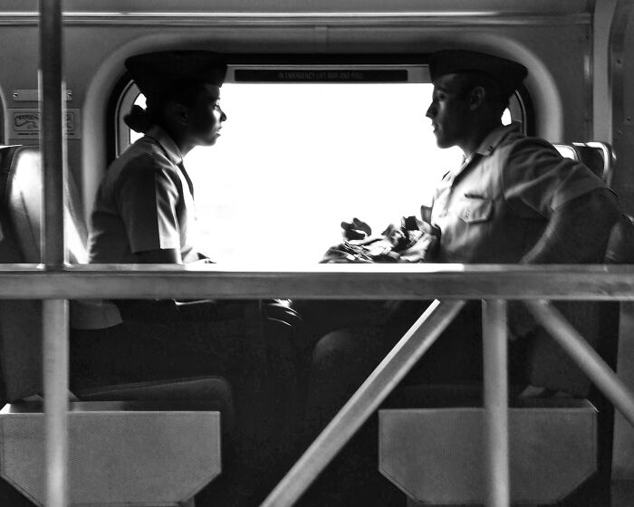 Two people in uniform having an intimate conversation on public transit, capturing Chicago street photo vibes.