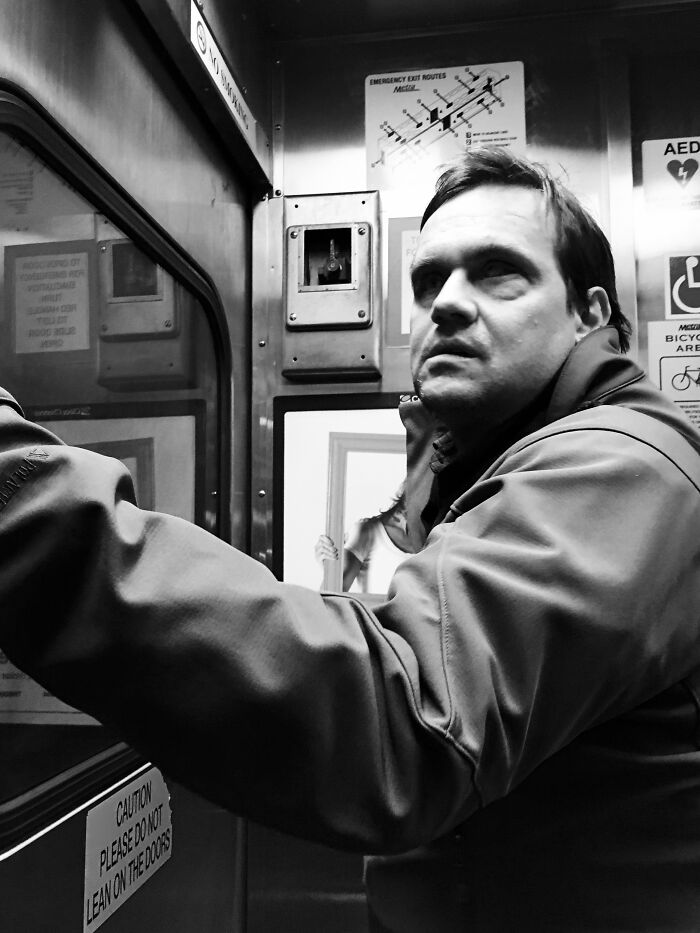 Man riding Chicago subway, captured in intimate street photo showcasing the city's everyday soul and atmosphere.