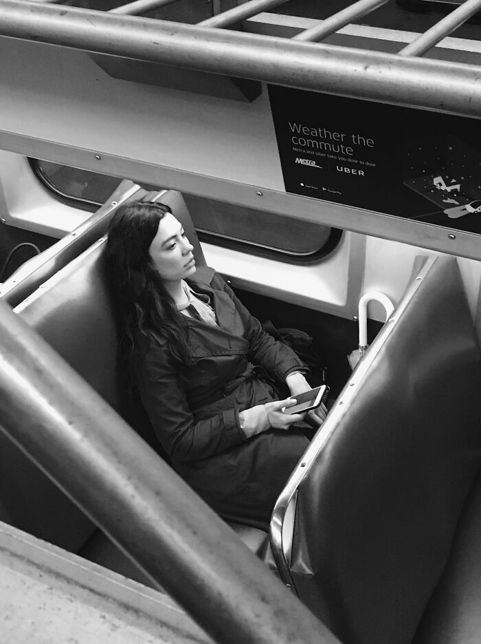 Woman holding phone on Chicago train, part of intimate street photos capturing the city’s soul by Chicago teacher.