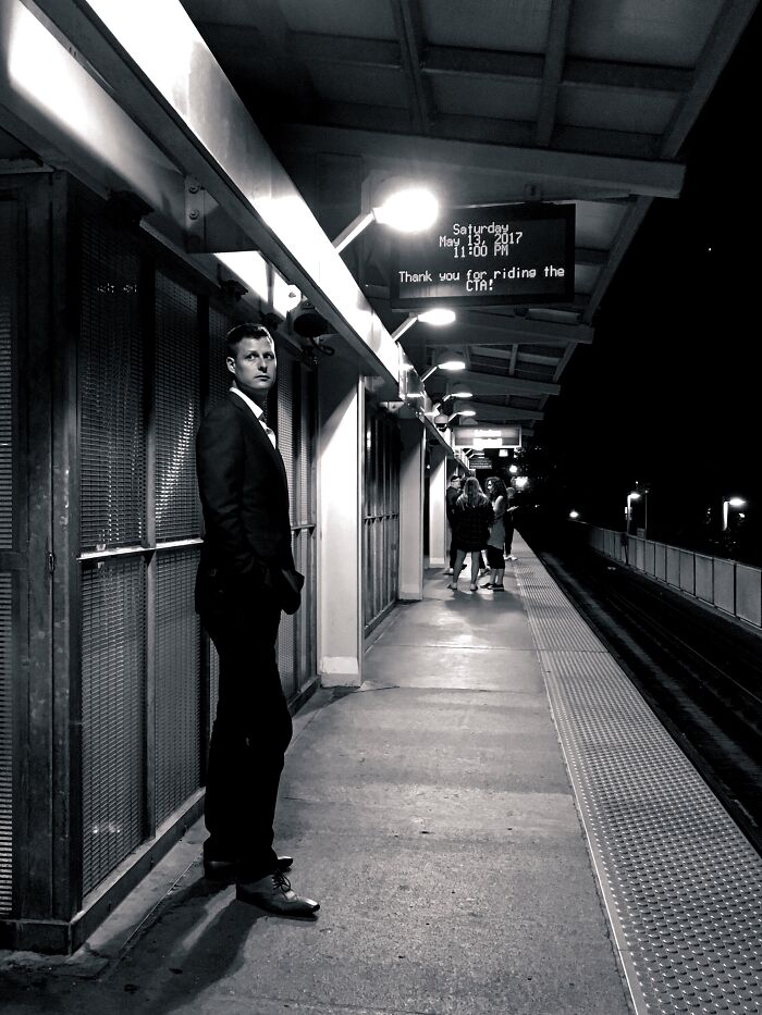 Man in a suit standing on a Chicago street at night, capturing intimate street photos of the city’s soul.