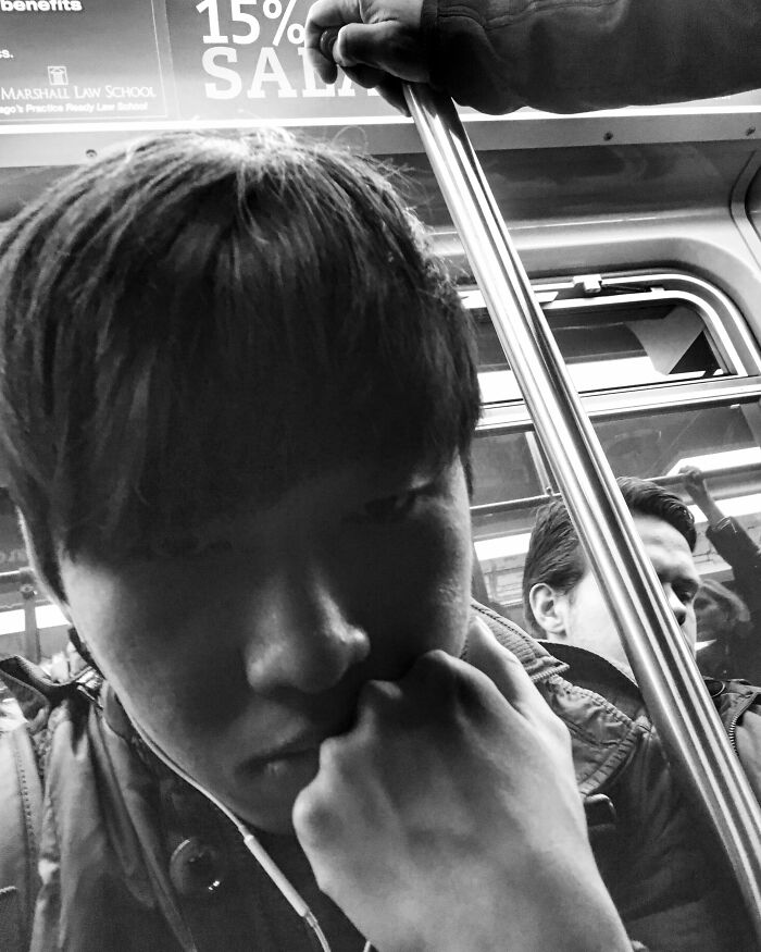 Black and white intimate street photo of a thoughtful man on public transit, capturing Chicago’s street life and urban soul.