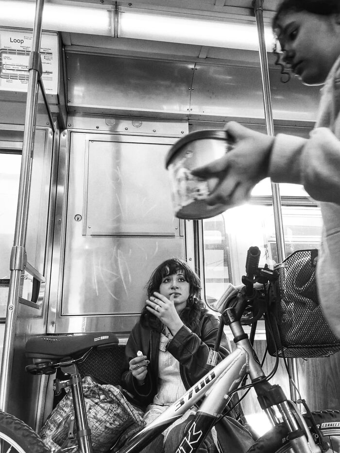 Black and white street photo capturing Chicago's soul with a woman on a train and a bike in an intimate urban moment.