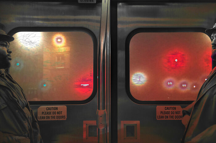 Man and woman facing each other on a Chicago subway, part of intimate street photos capturing the city's soul at night.
