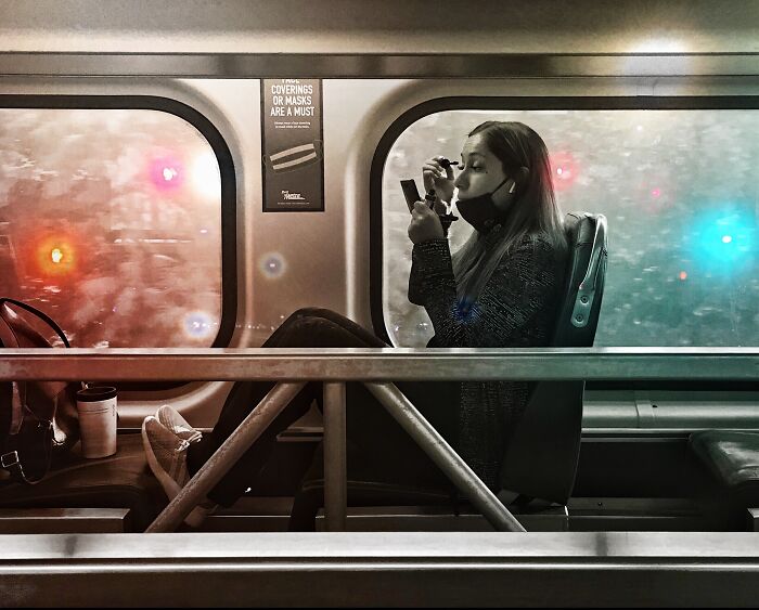 Woman wearing a mask on Chicago train, captured in intimate street photo reflecting the city’s soul and everyday moments.