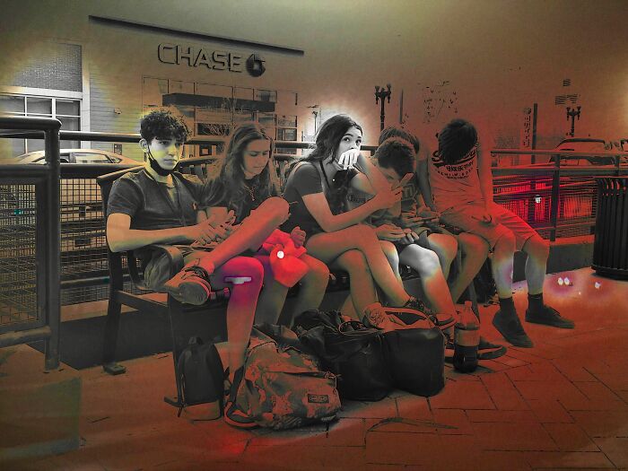 Group of young people sitting on a bench in Chicago street, an intimate street photo capturing the city’s soul at night.