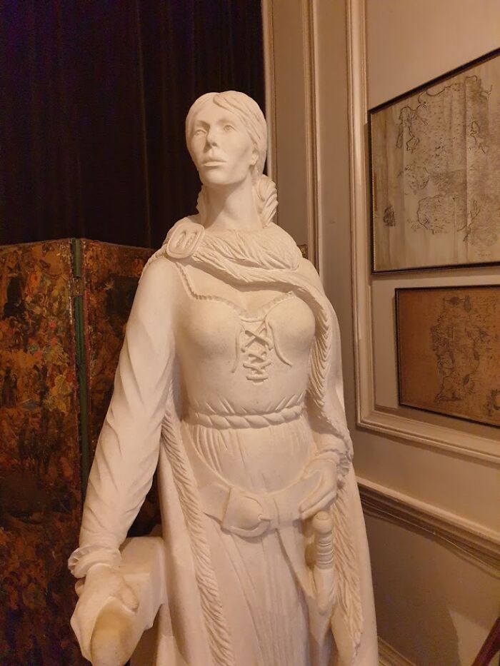 White marble statue of Grace O’Malley dressed in historic attire, symbolizing her role in commanding ships and fighting armies.