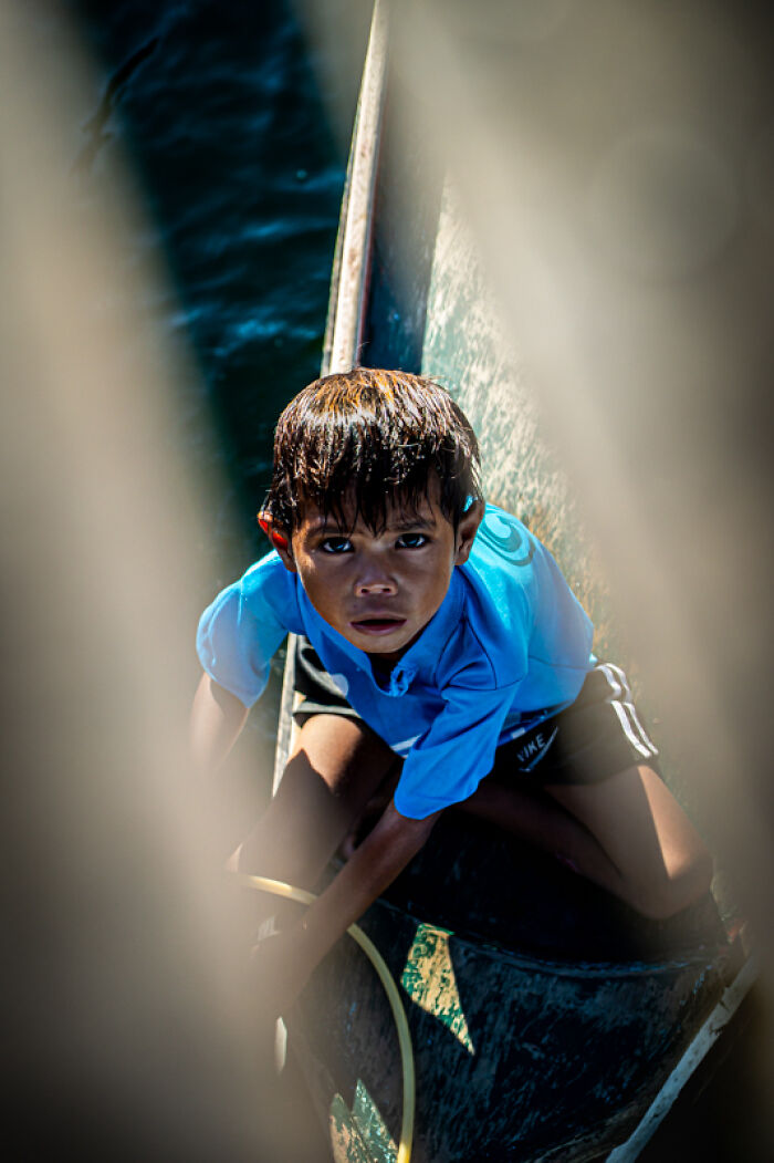 Young boy in a blue shirt captured candidly in street photos showcasing the quiet beauty of everyday life by Joseph Cheung