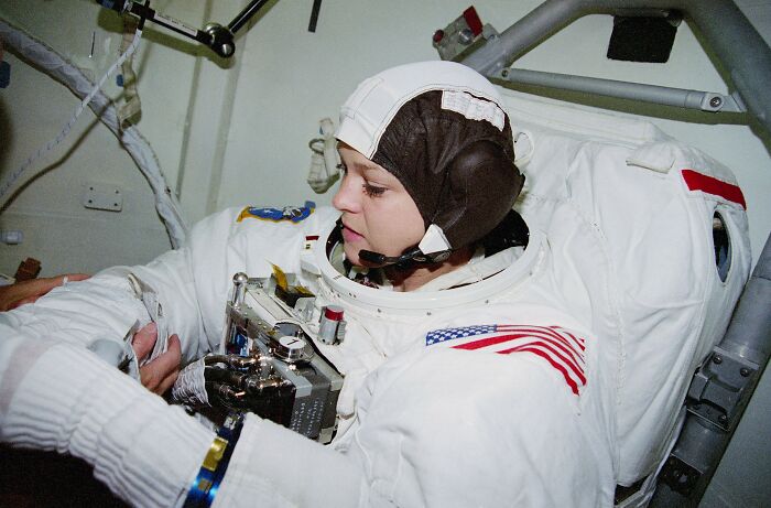 Astronaut in space suit inside spacecraft, illustrating intriguing and bizarre astronaut facts about space exploration and training.