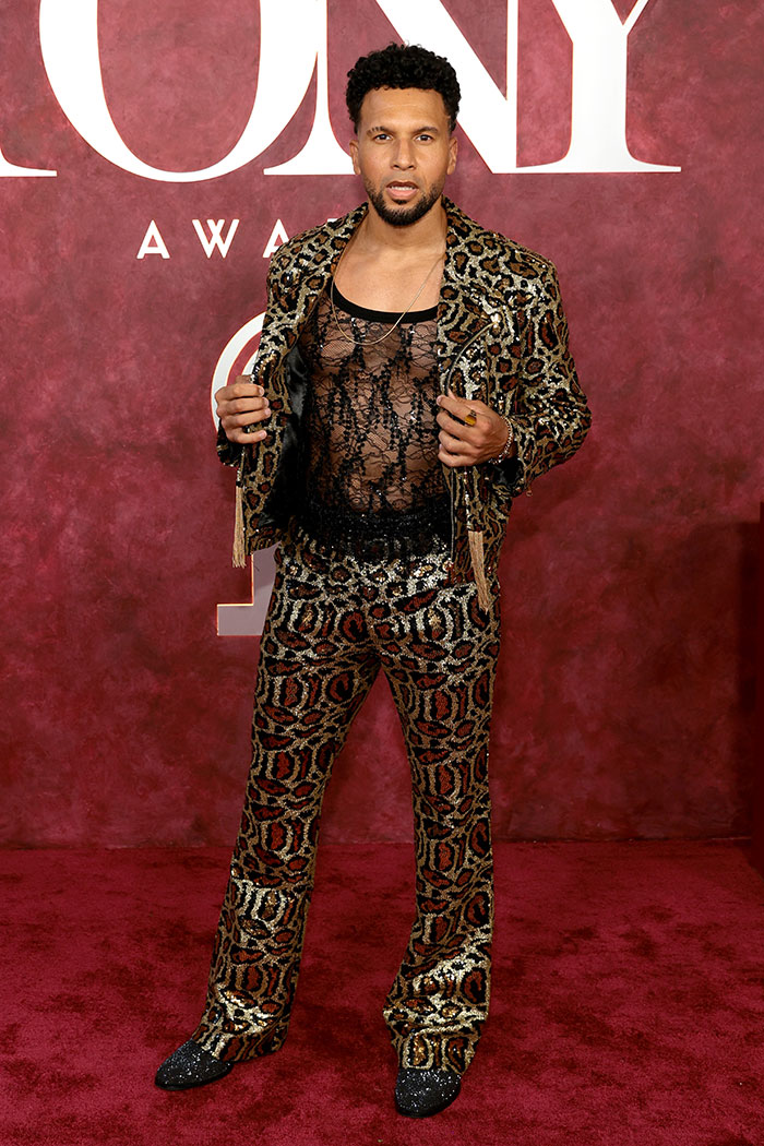 Man in leopard print suit and sheer black lace shirt posing on red carpet at 2025 Tony Awards worst dressed stars event