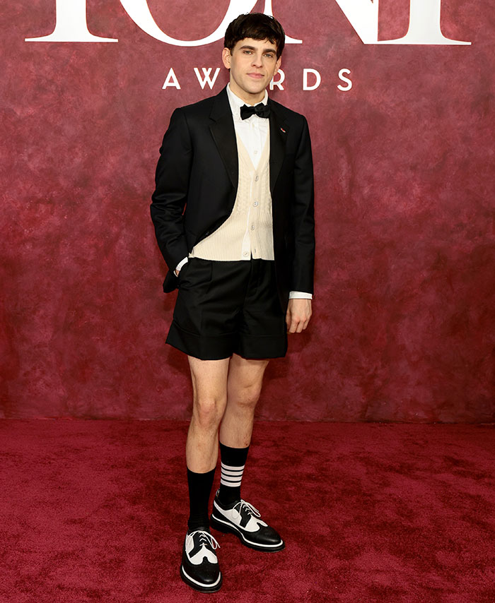 Young man on the Tony Awards red carpet wearing a black tuxedo jacket with shorts and two-tone shoes, worst dressed stars 2025.