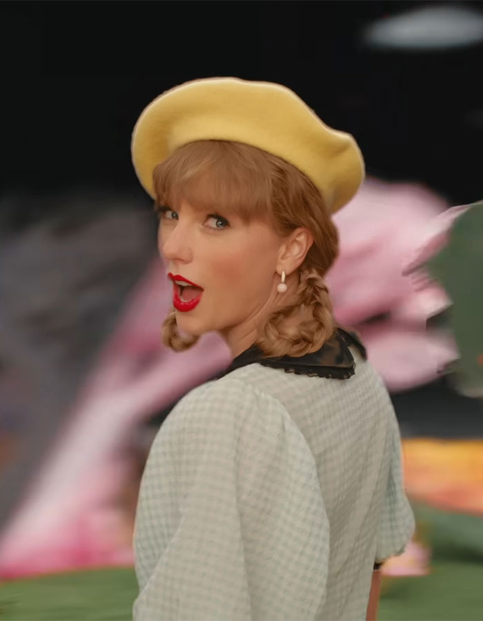 Taylor Swift as Dorothy in the new Wicked movie, wearing a yellow beret and vintage-style outfit with braided hair.