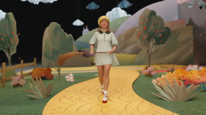 Taylor Swift as Dorothy on the yellow brick road set in the new Wicked movie, fans react to her silent role.