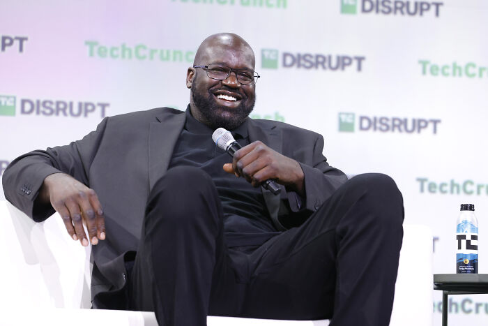 Man in black suit holding microphone and smiling during a panel discussion at a TechCrunch Disrupt event.