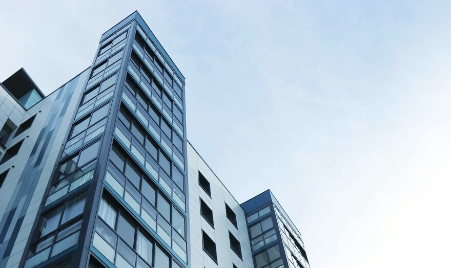 Modern glass building reflecting the sky, illustrating urban development for the Then vs Now poll concept.
