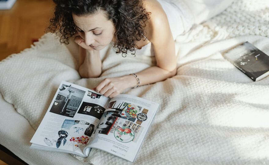 Woman lying on bed reading a magazine, illustrating a Then vs Now poll on lifestyle and trends comparison.