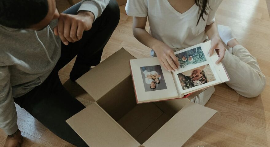 Two people sitting on the floor looking at a photo album, reflecting in a then vs. now poll comparison.