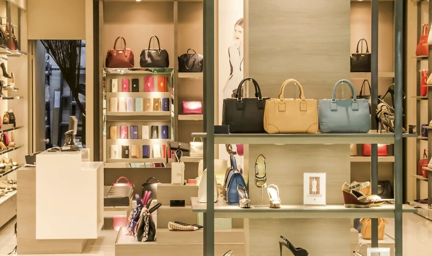 Luxury handbags and shoes displayed on shelves in a brightly lit store for a then vs. now poll comparison.