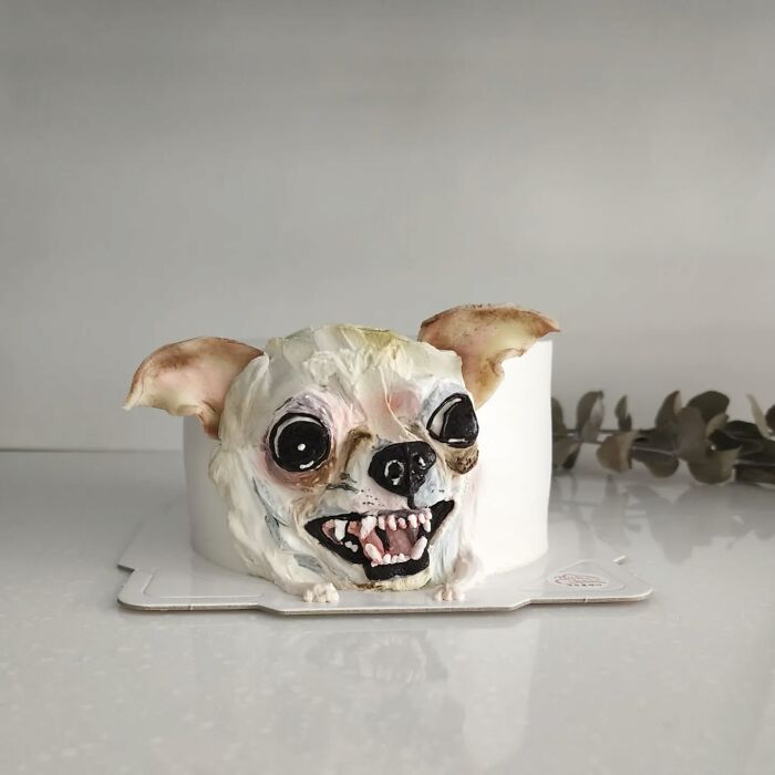 Pet-themed cake shaped like a small dog with detailed facial features capturing its unique personality.