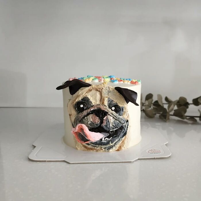 Adorable pet-themed cake shaped like a pug with detailed frosting capturing the dog's unique personality and features.