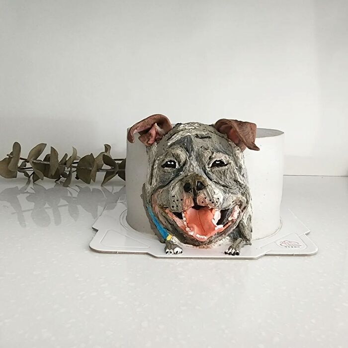 Adorable pet-themed cake shaped like a happy dog capturing its unique personality on a white surface.