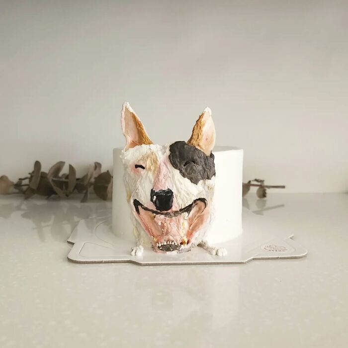 Pet-themed cake shaped like a smiling dog with detailed frosting capturing the pet's unique personality.