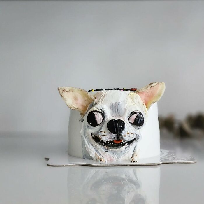 Pet-themed cake shaped like a dog head with detailed frosting capturing its unique personality and features.