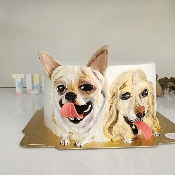 Pet-themed cake featuring two dogs with detailed faces and tongues out, showcasing unique personality in adorable design.