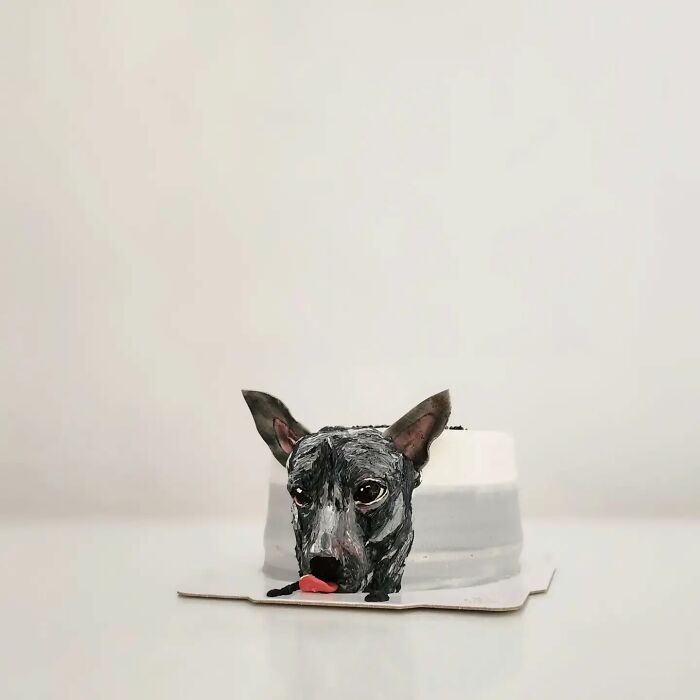 Black dog cake with detailed face and ears, an adorable pet-themed cake capturing unique personality.