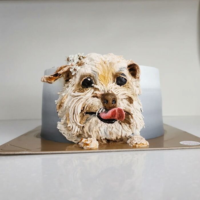 Detailed pet-themed cake shaped like a fluffy dog with tongue out, showcasing adorable design and unique personality.