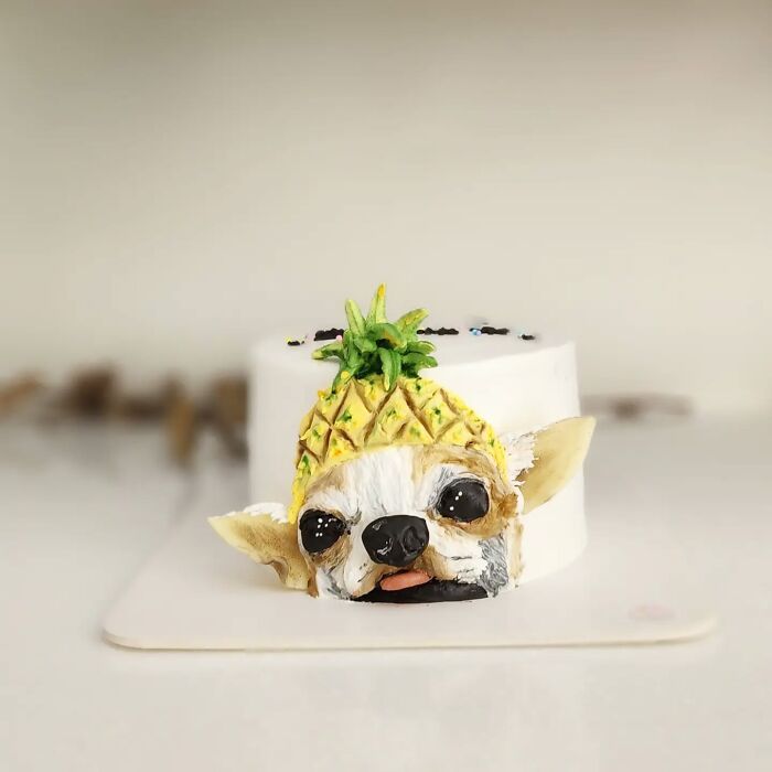 Pet-themed cake shaped like a dog wearing a pineapple hat, showcasing adorable and creative pet cake design.