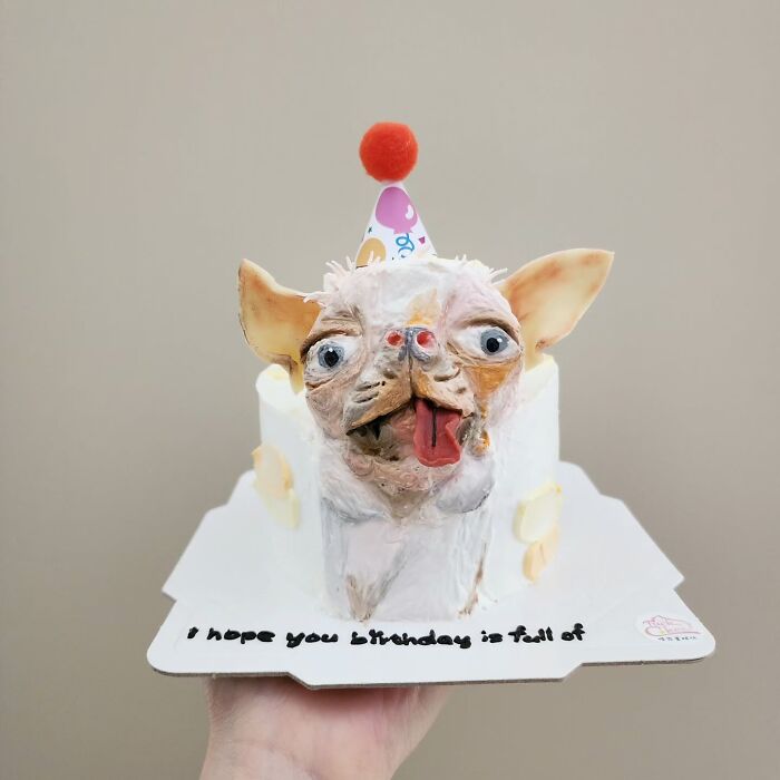 Adorable pet-themed cake shaped like a dog wearing a colorful party hat, capturing its unique personality and charm.