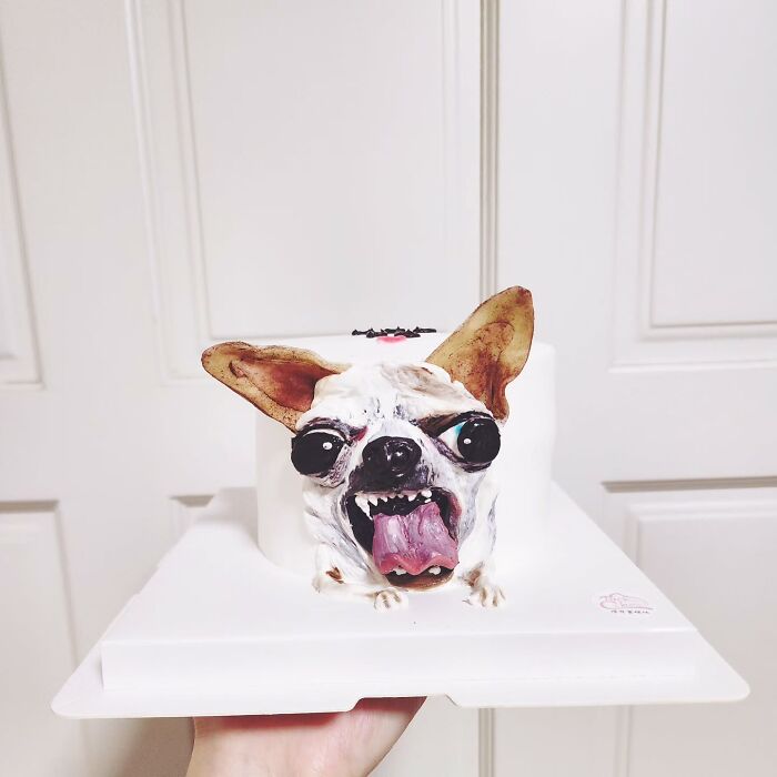 3D pet-themed cake of a dog with tongue out, showcasing artist's skill in creating adorable pet-themed cakes.
