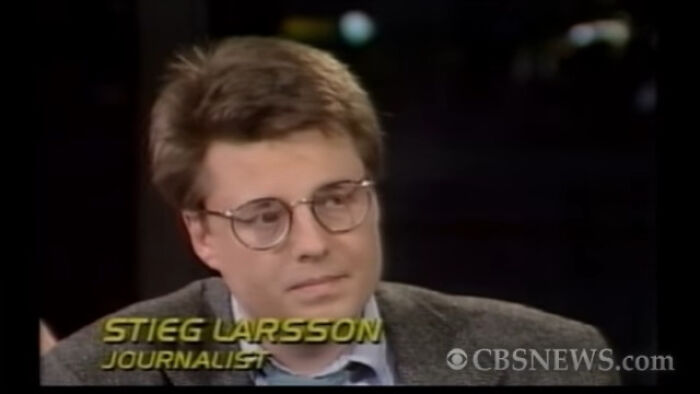Man with glasses and brown hair in a gray jacket speaking during a CBS News interview about Nikola Tesla.