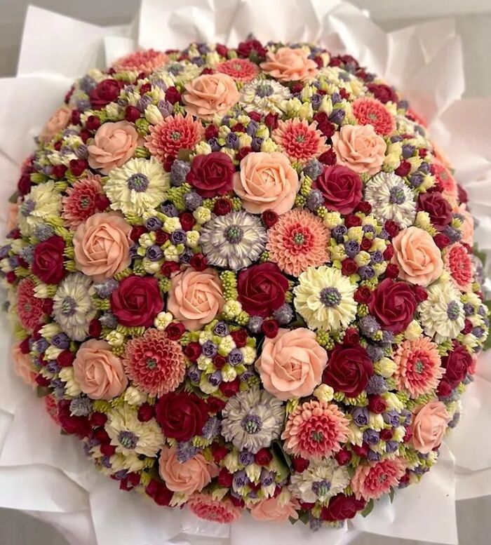 Intricately decorated baked goods resembling a flower bouquet with roses and various blossoms in vibrant colors