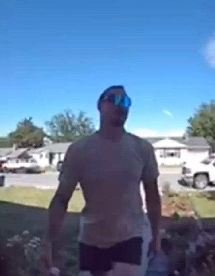 Man wearing sunglasses walking outside in a sunny neighborhood, related to after 3 sisters suffocated by dad in the woods.
