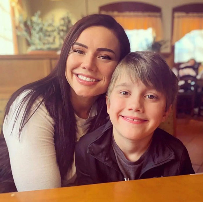 Whitney Purvis from 16 And Pregnant smiling with young son in a warm indoor setting.