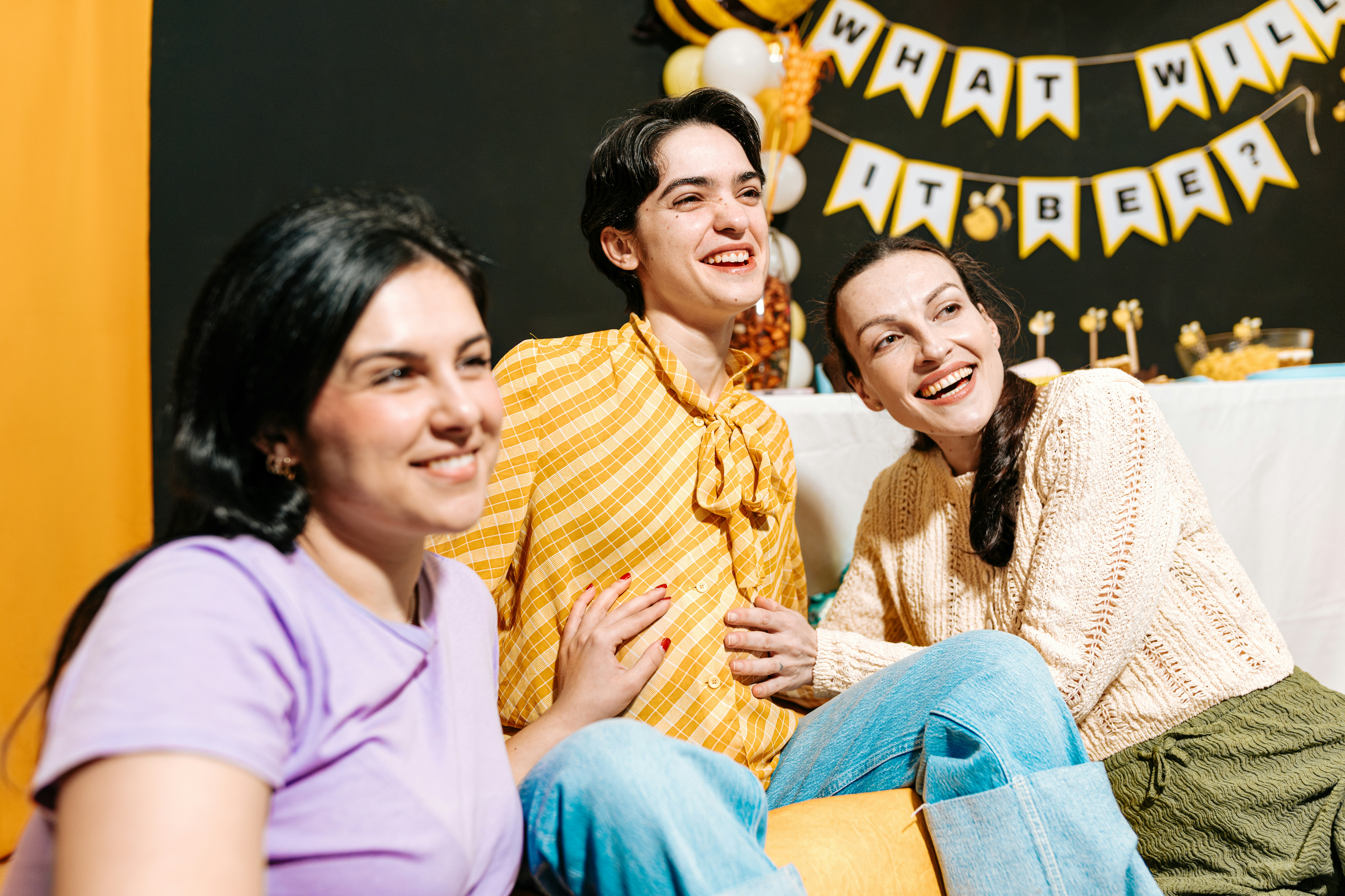 Three women smiling and laughing indoors, reflecting boundaries and a woman having enough of her friend using her.