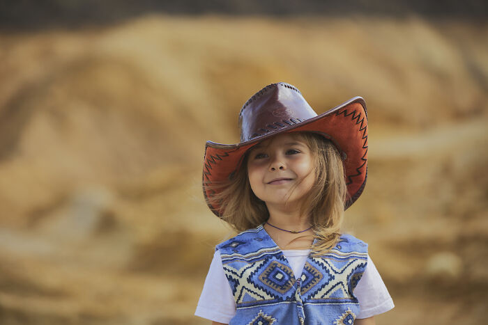 Young child wearing a cowboy hat and patterned vest, representing baby names that secretly weird people out.