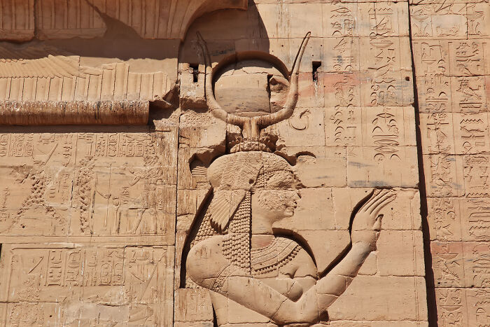 Ancient Egyptian relief carving of a deity on a sandstone wall with hieroglyphs, highlighting unique baby names inspiration.