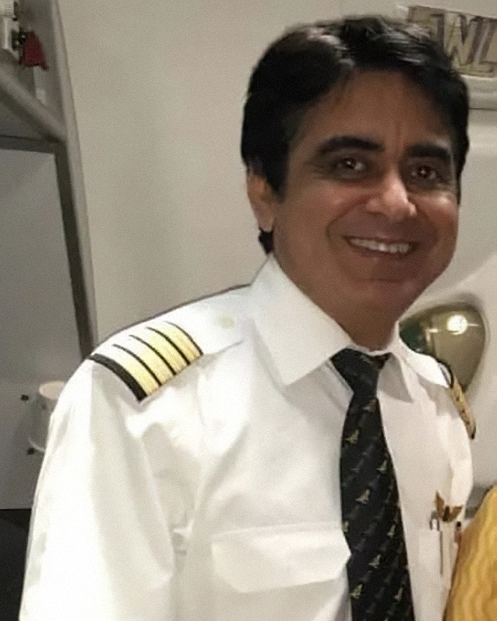 Air India pilot in uniform smiling, recognized as a hero for his final act that saved hundreds in a tragic crash.