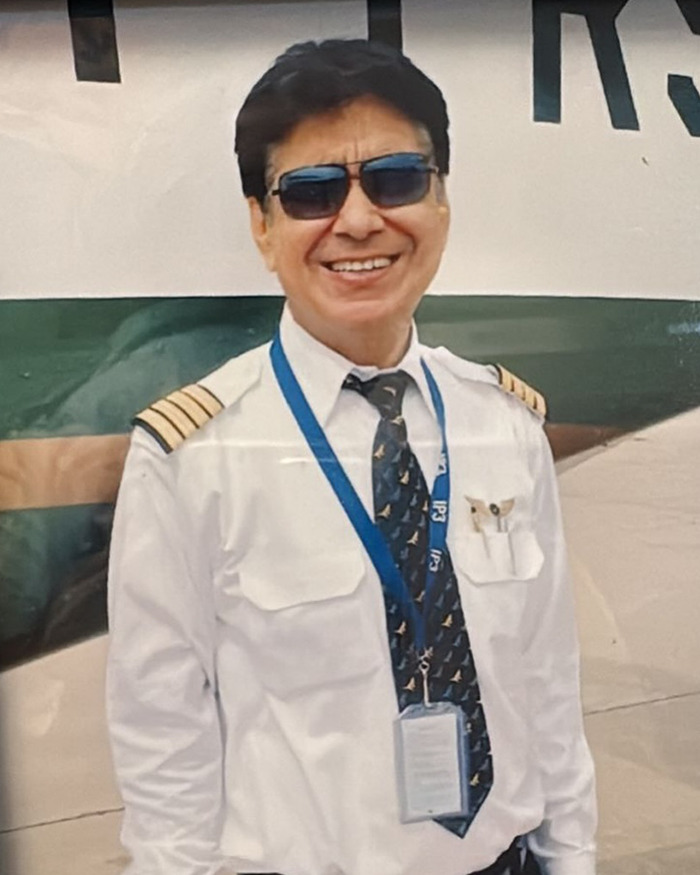 Air India pilot in uniform with sunglasses, smiling, recognized as a hero for saving hundreds in a tragic crash.