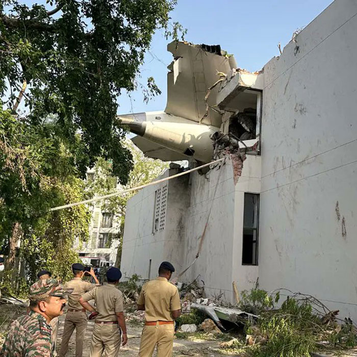 Air India survivor's guilt shown with plane wreckage inside a damaged building and officials inspecting the site.