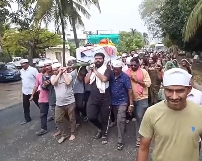 Mourners carrying a coffin during a funeral procession, symbolizing the sole survivor of Air India crash's final act.